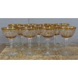 A set of eleven champagne coupes each with engraved amber coloured bowl over a hexagonal faceted