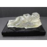 A paperweight with a frosted glass model of a sleeping child on a rectangular black glass base