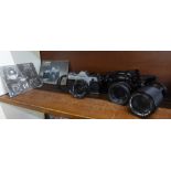 Two Canon 35mm film cameras, A-1 black body and AE-1 silver/black body, both with 50mm lenses and
