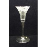 A wine glass, circa 1730, engraved floral trumpet bowl over plain stem and wide conical foot, 17.5cm