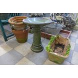 Six terracotta plant pots and a small green glazed terracotta bird bath