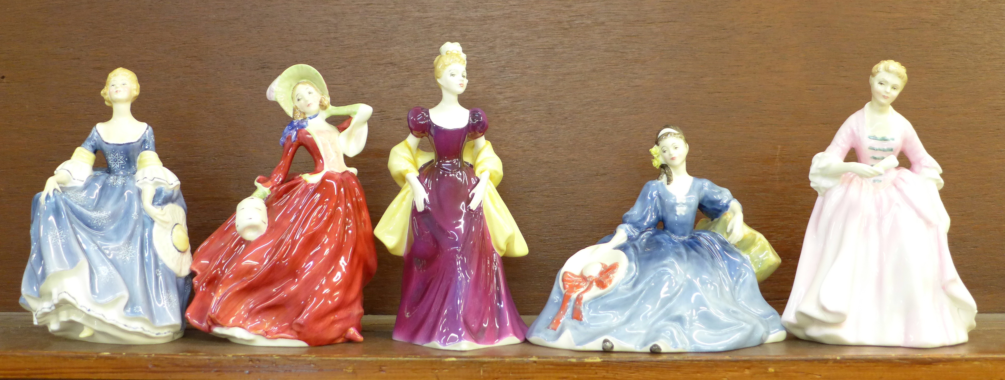 Five Royal Doulton figures; Autumn Breezes, Hilary, Loretta, The Hostess of Williamsburg, a/f, and