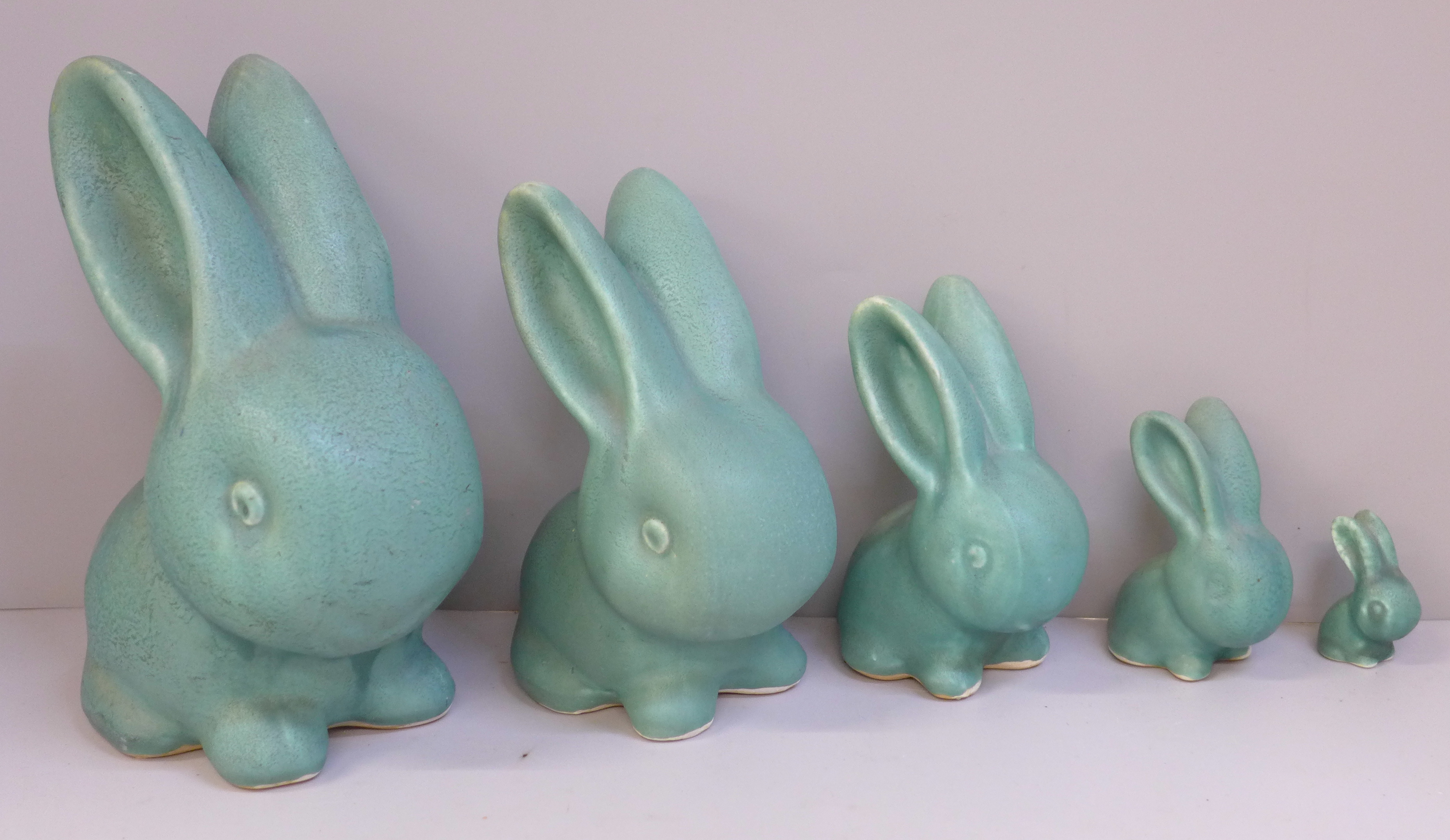 A graduated set of five Bourne Denby rabbits with matt green glaze