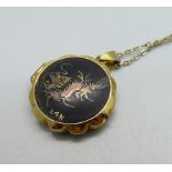 An oriental Damascene locket with 24ct gold inlaid detail