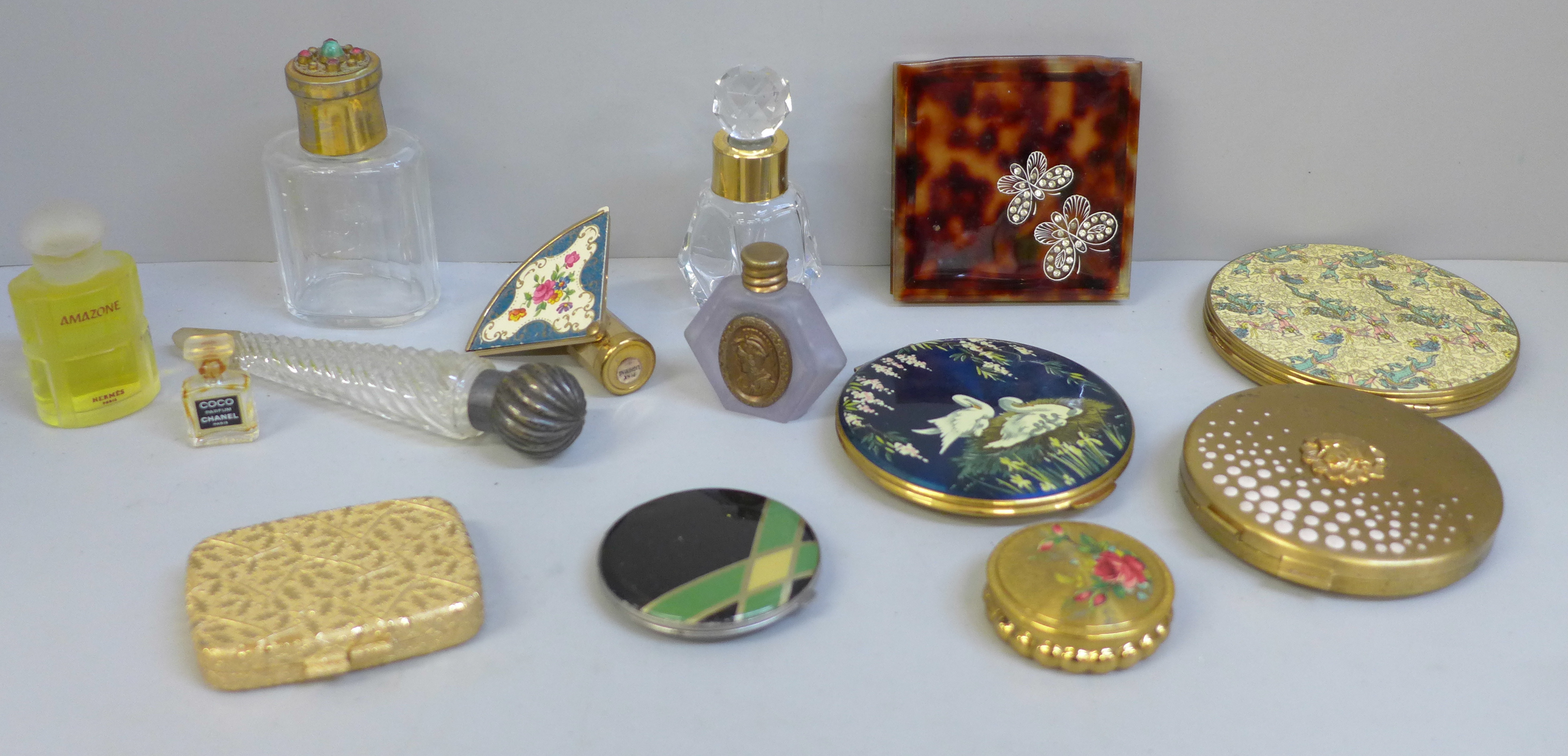 A collection of compacts and perfume bottles including Chanel No.5 miniatures