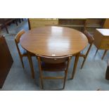 A teak circular extending dining table and four chairs