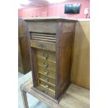 A Victorian oak fitted tambour front index drawer cabinet