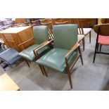 A pair of teak and green vinyl armchairs