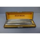 A Hohner The 64 harmonica, cased