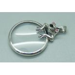 A silver frog magnifying glass pendant