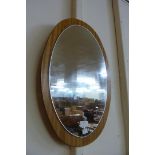 An oval teak framed mirror