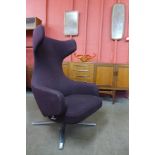 A Vitra Grand Repos chrome and aubergine fabric upholstered revolving lounge chair, designed by