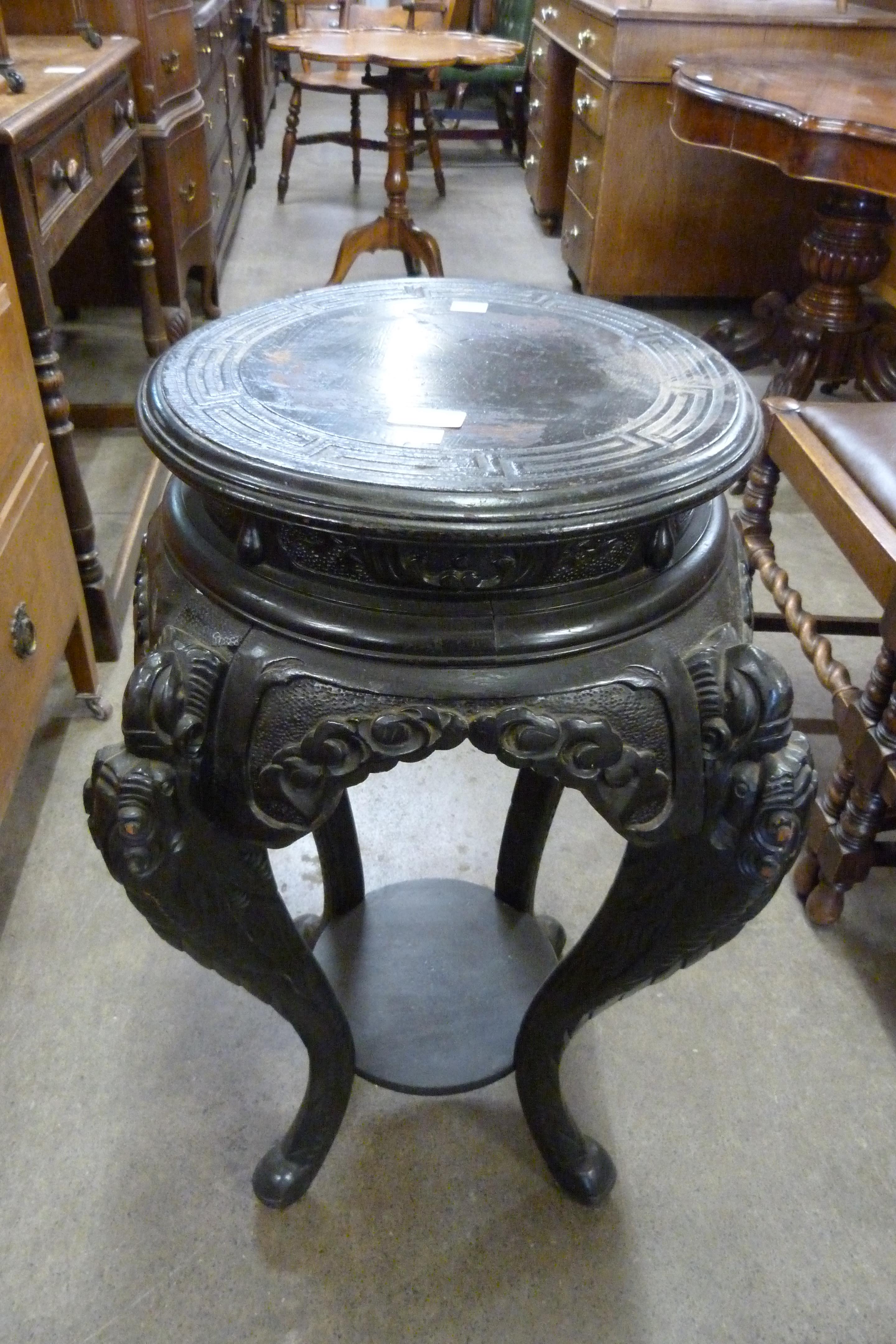 A Chinese carved ebonised jardiniere stand