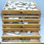 A set of six wooden drawers containing pocket watch movements, dust covers and dials, for repair