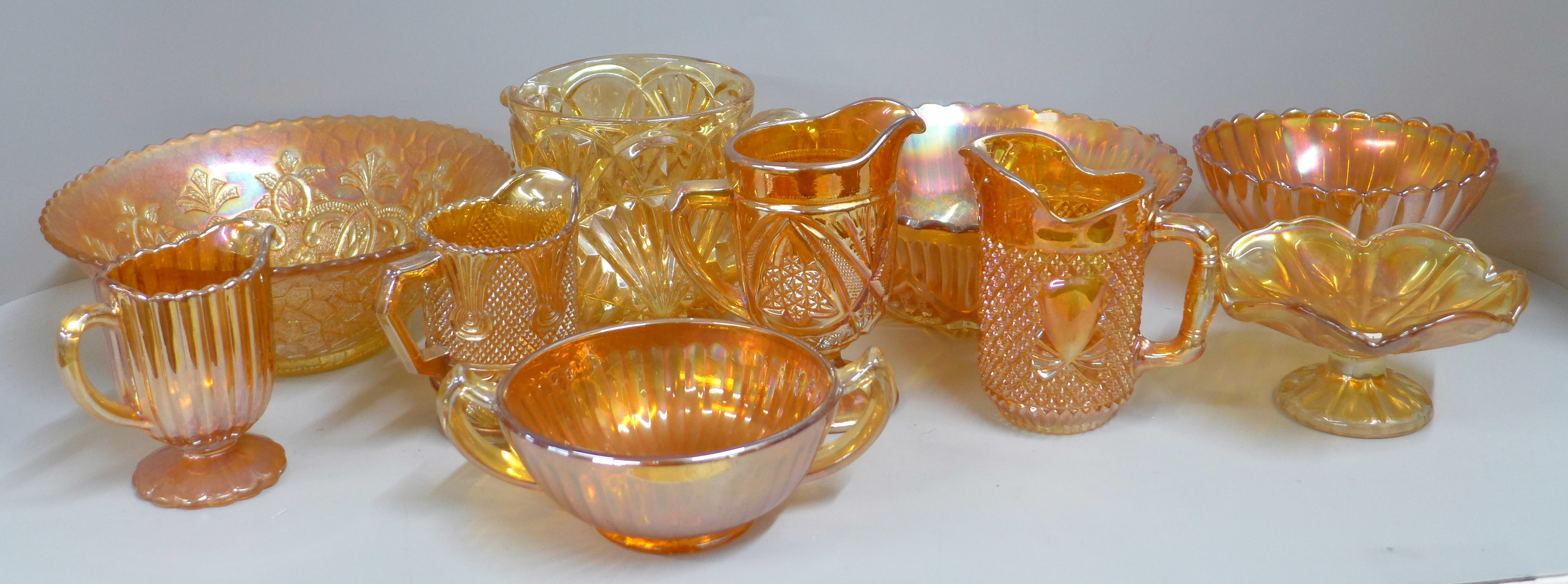 Ten items of marigold carnival glass, five jugs/pitchers, two pedestal bowls, other bowls