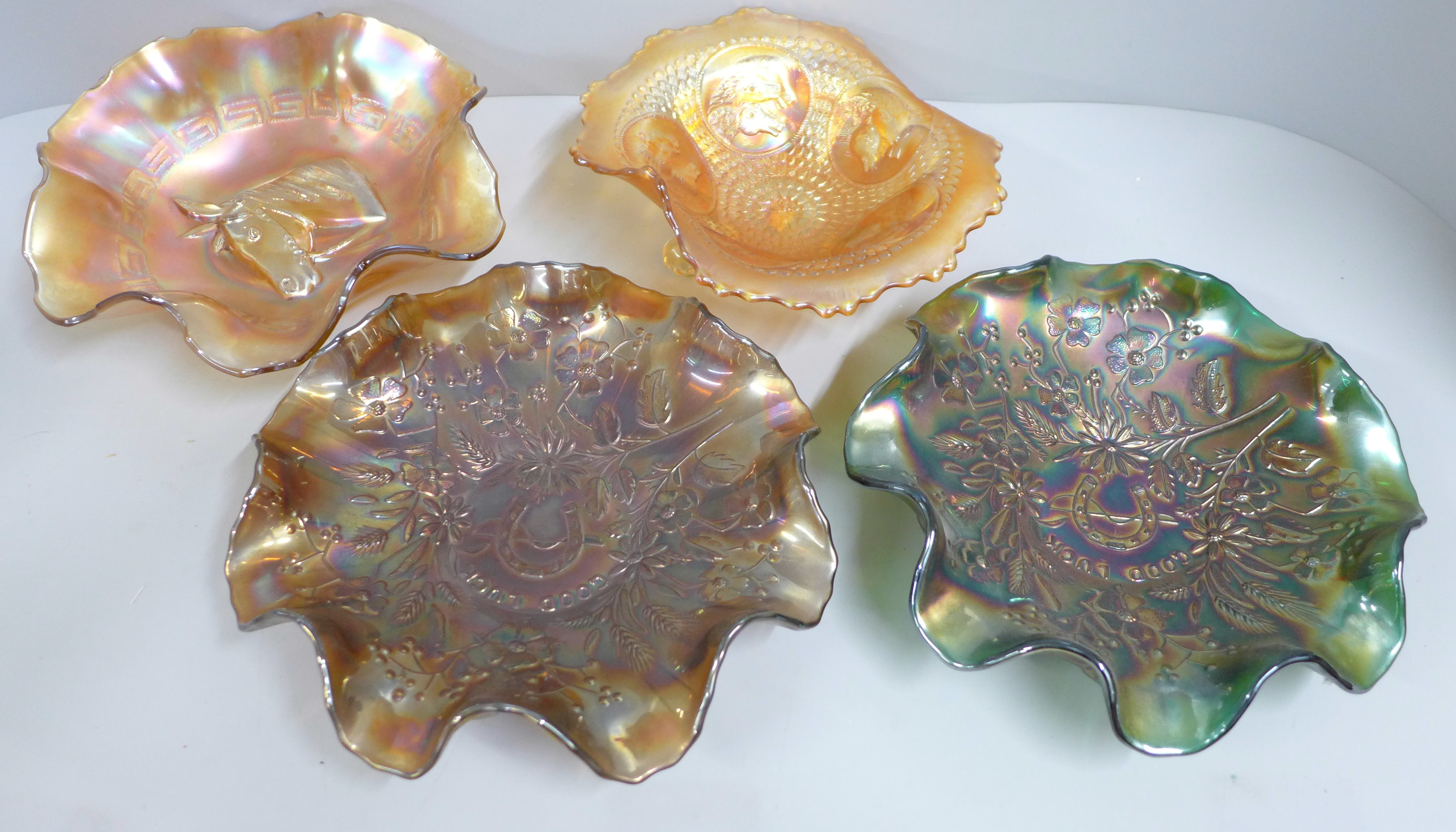 Four carnival glass bowls, two 'Good Luck', one Racehorse and one Horse Medallion, iridescent green,