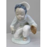 A Lladro figure of a child playing baseball