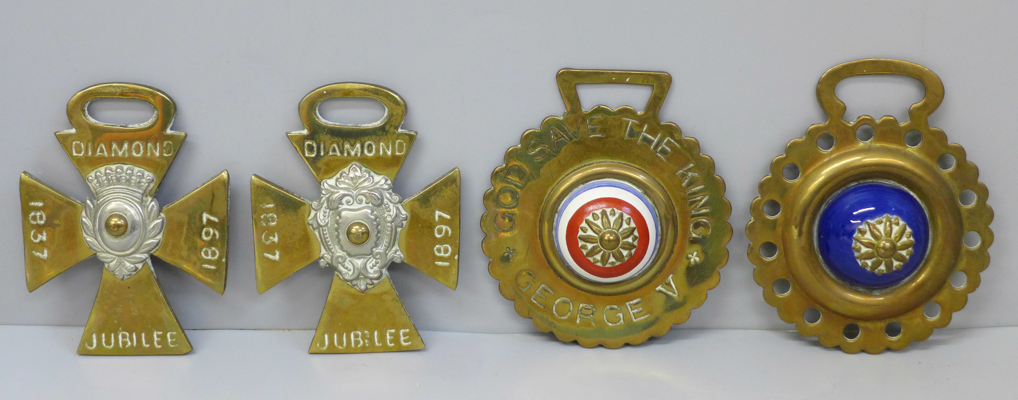 A collection of four horse brasses, two 1897 Jubilee, King George V and one other