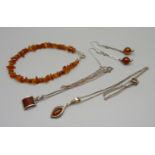 Two silver and amber pendants and chains, a pair of silver and amber drop earrings and an amber