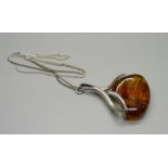 A large silver and amber set pendant on a silver chain