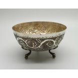 A three legged embossed silver bowl, marked 830, 69g