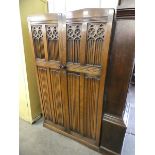 A carved oak linenfold bachelors wardrobe