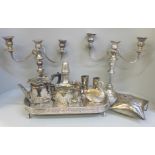 A pair of silver plate on copper candelabra, lacking one sconce, a silver plate on copper tray, a