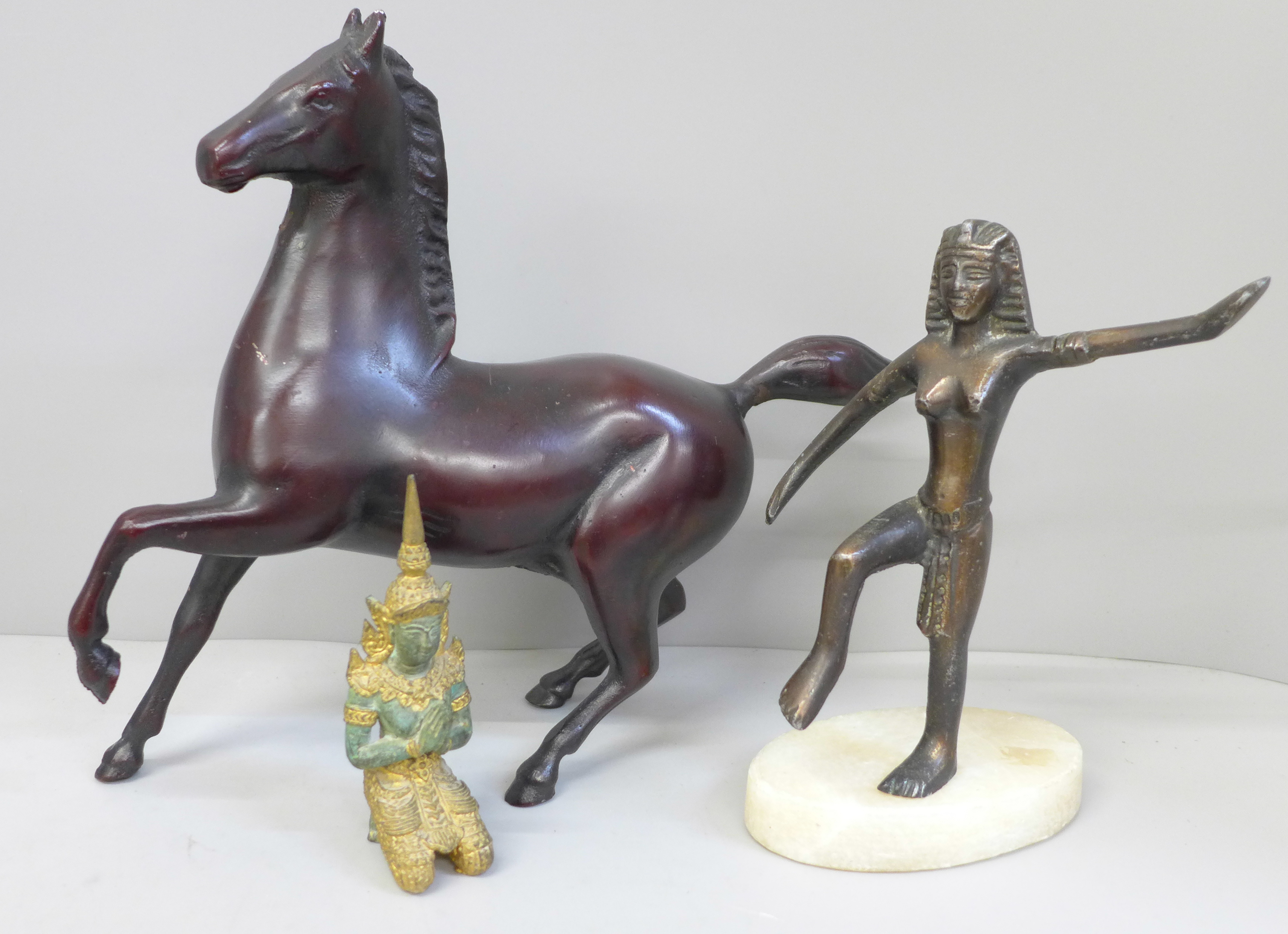 A metal model of a horse and two other figures