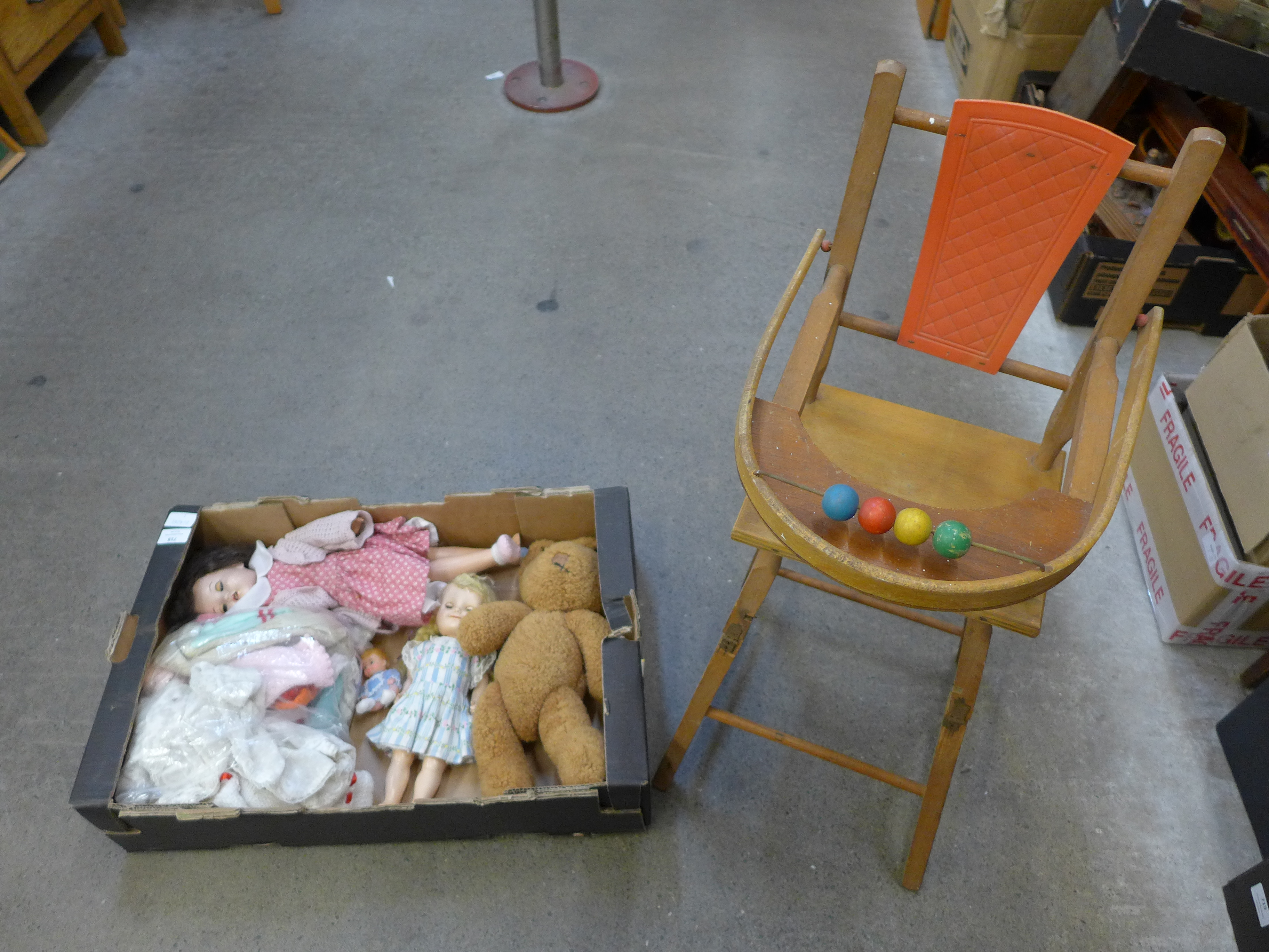 A collection of vintage dolls and a high chair