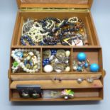 A jewellery box containing costume jewellery and wristwatches