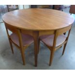 A Nathan teak circular extending dining table and four chairs