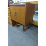 A teak two door cabinet on stand