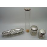 Three silver topped glass jars and a silver topped glass bottle