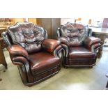 A pair of oxblood red leather armchairs