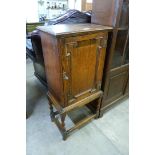 An early 20th Century oak smokers cabinet on barleytwist stand