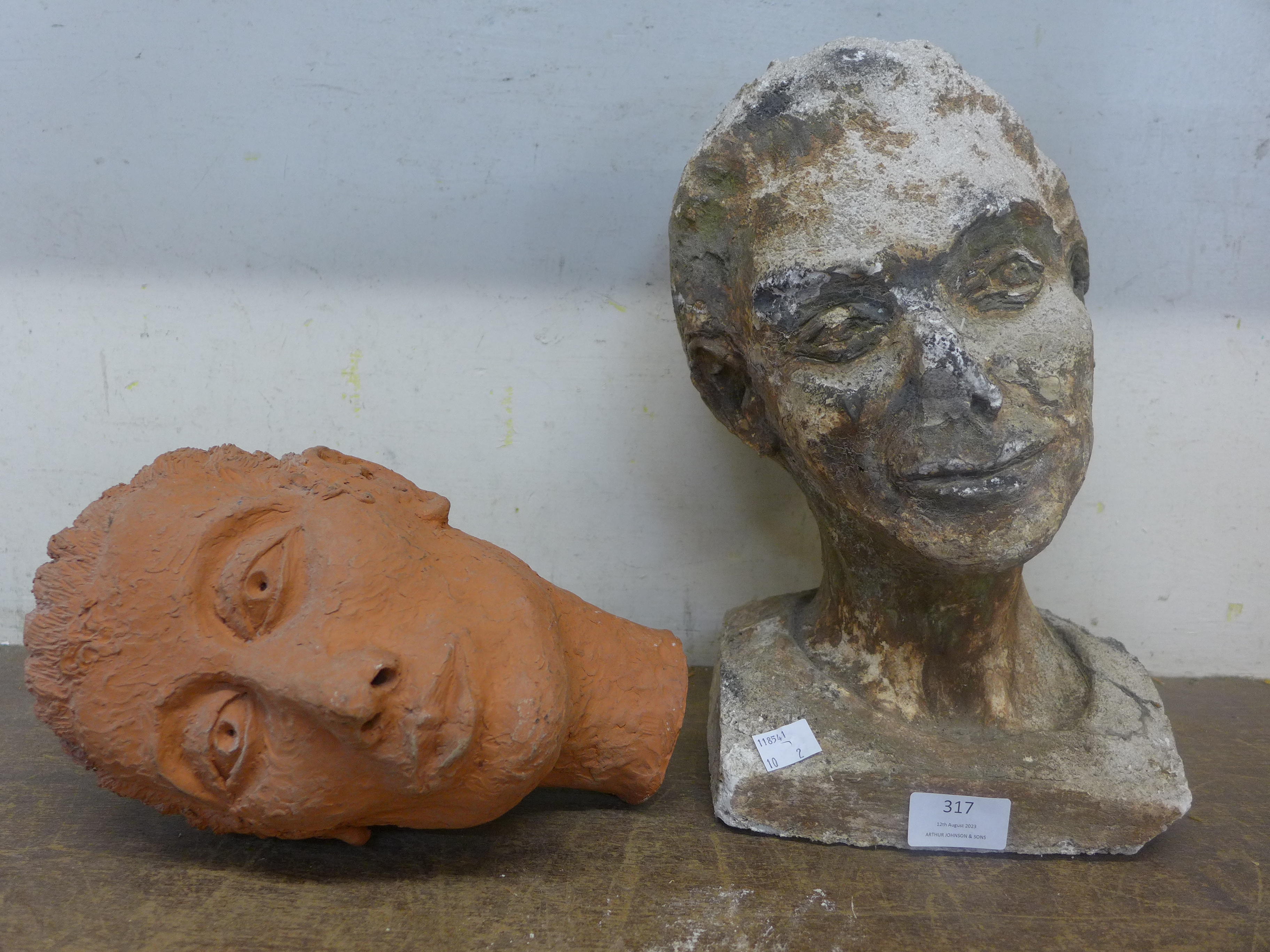 A terracotta lady's head and a faux stone lady's head