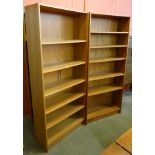 A pair of tall teak open bookcases