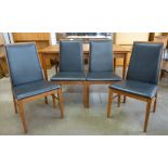 A set of four Danish Dyrlund teak and black vinyl dining chairs