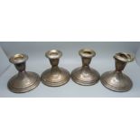 A set of four silver candlesticks, one a/f, 8.5cm