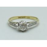 An 18ct gold and platinum set diamond solitaire ring with diamond shoulders, 2g, N