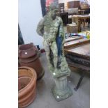 A concrete garden figure of a classical male nude and a pedestal