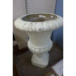 A concrete campana shaped garden urn