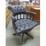 A mahogany and leather revolving Captain's desk chair