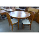 A McIntosh teak circular extending dining table and four teak dining chairs