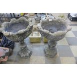 A pair of concrete garden planters on stands