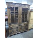 A 17th Century style carved Ipswich oak four door bookcase