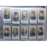 Cigarette cards; an album of military themed cigarette and trade cards, (11) complete sets including