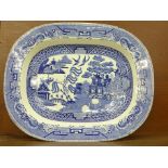A large Willow pattern serving plate, chips to the rim