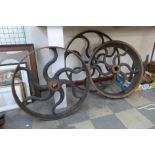 Three large industrial cast iron wheels