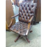 A mahogany and chestnut brown leather revolving desk chair